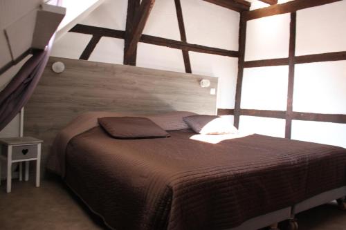 a bedroom with a bed in a room with windows at Appartement les Violettes in Colmar
