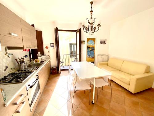 eine Küche und ein Wohnzimmer mit einem Tisch und einem Sofa in der Unterkunft Casa Marzia by Housilia in Cefalú