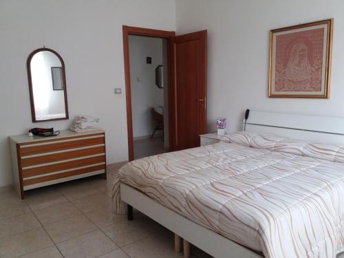 - une chambre avec un lit, une commode et un miroir dans l'établissement Casa vacanze Lida, à Marina di Carrara