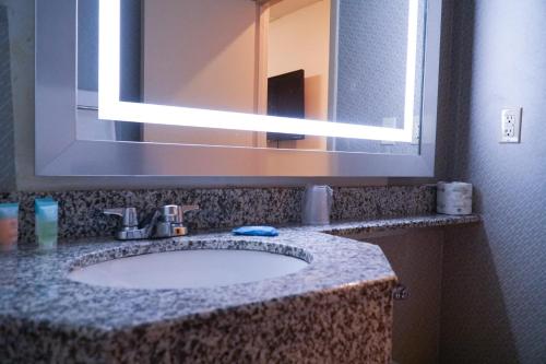 a bathroom with a sink and a large mirror at Cabana Hotel Yankee Stadium in Bronx