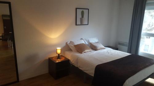 1 dormitorio con 1 cama y 1 lámpara en una mesa en Résidence Provence, en Marsella