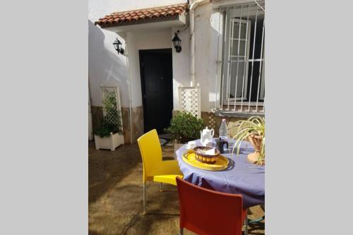 einen Tisch mit einem blauen Tischtuch und gelben Stühlen in der Unterkunft ApartF32020 in El Biar