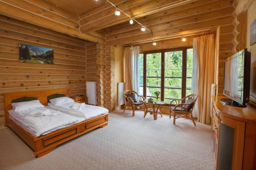 a bedroom with a bed and a table with chairs at Вілла Тростян Резорт in Slavske