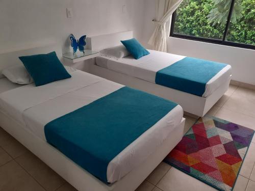 two beds sitting in a room with at Villa Zully in Villeta