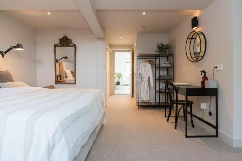 1 dormitorio con cama, escritorio y espejo en Empire suites roof terras en Ámsterdam
