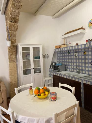 a kitchen with a table with a bowl of fruit on it at Casa Vacanze Marco Polo vista mare in Trappeto
