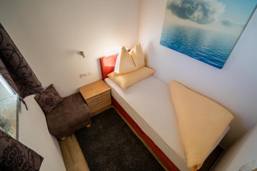 a small room with a bed and a painting on the wall at Alpenhof Chalets in Gerlos