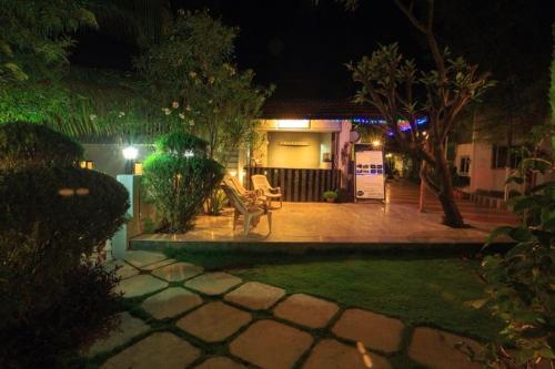 a house with two chairs in a yard at night at Anandvan Holiday Homes, Wai in Wai