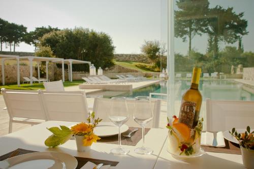 a bottle of wine sitting on a table with glasses at Podere Santa Chiara in Otranto