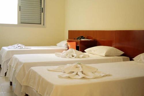 two beds in a hotel room with towels on them at Hotel Morada do Sol in Araxá