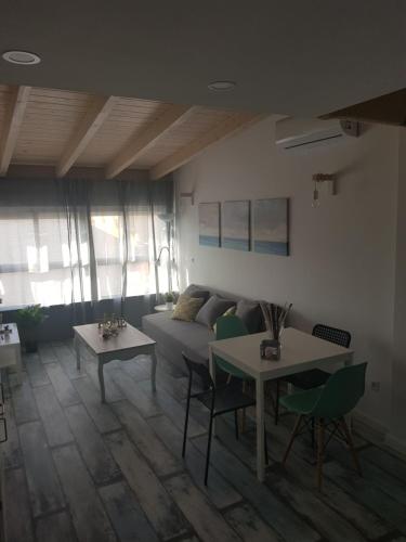 a living room with a couch and two tables at APT 5 - Apartamento en la playa de El Palo in Málaga