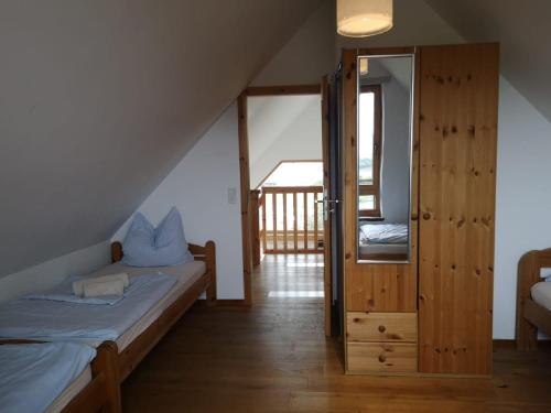 a attic room with a bed and a sliding glass door at 1Austragshaus Andermichlhof in Geltendorf