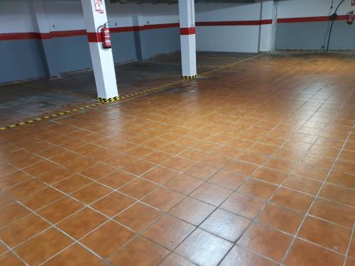 a room with a brown tiled floor and white poles at Rico Apartaments Ricosol in Torrox Costa