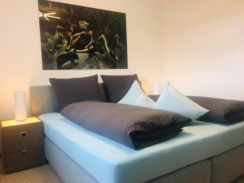 a blue couch with pillows and a painting on the wall at Astrid's Pension in Winterberg