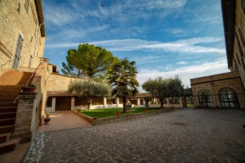 a courtyard of a building with trees in the background at il Monastero di Bevagna in Bevagna