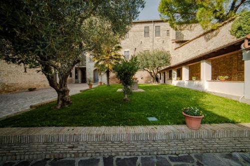 a yard with trees and a brick building at il Monastero di Bevagna in Bevagna