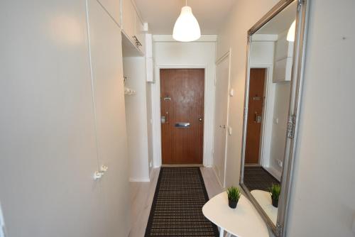 La salle de bains est pourvue d'un miroir, d'un lavabo et d'une porte. dans l'établissement Rental Apartment Kaski Vuokramajoitus Oy, à Turku