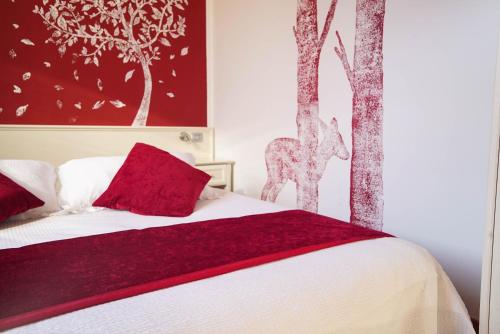 Hotel Il Crinale في Grizzana: غرفة نوم بسرير ومخدات حمراء واشجار
