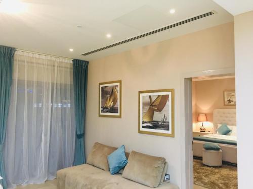 JCB Dubai Marina Apartment في دبي: غرفة معيشة مع أريكة وسرير