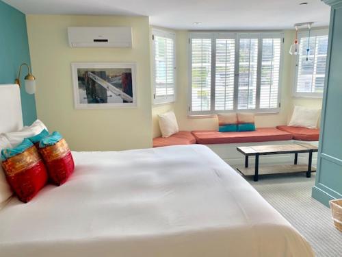 a bedroom with a large white bed with red pillows at Inn at Playa del Rey in Los Angeles