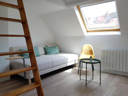 a living room with a white couch and a window at FleuryBis - Appartement calme proche de Rouen in Déville-lès-Rouen