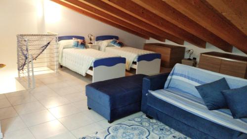 ein Wohnzimmer mit 2 Betten und einem Sofa in der Unterkunft Delle Rose apartment in Eraclea Mare