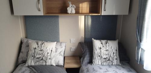 a small bedroom with two beds and a cabinet at Bonnie Gorm in Boat of Garten