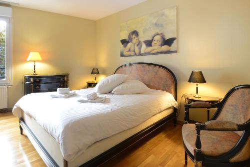 - une chambre avec un grand lit blanc et 2 chaises dans l'établissement COLMAR - Appartement "LE ROESSELMANN 2" -, à Colmar