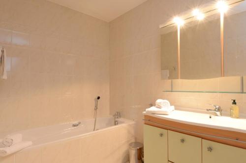 La salle de bains est pourvue d'une baignoire, d'un lavabo et d'une baignoire. dans l'établissement COLMAR - Appartement "LE ROESSELMANN 2" -, à Colmar