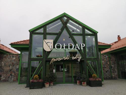 a glass building with the words adap inside of it at Mazurski Staw in Gołdap