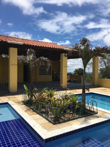 a resort with a swimming pool and palm trees at flat em serra negra - bezerros in Bezerros