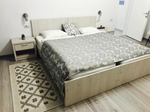 a large bed in a bedroom with two night stands at Abby in Câmpulung Moldovenesc