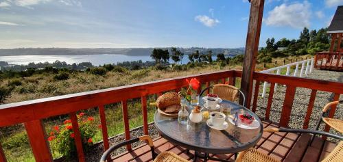 a table on a balcony with a view of the water at Terrazas de Nercon in Castro