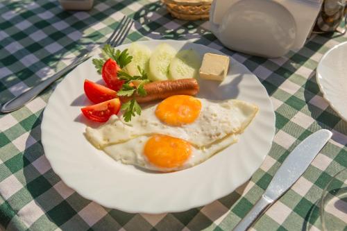 une assiette de nourriture avec des œufs et des fruits sur une table dans l'établissement Вілла Тростян Резорт, à Slavsko