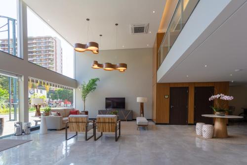 a lobby with chairs and a table in a building at Hotel Villa Fiori in Poços de Caldas