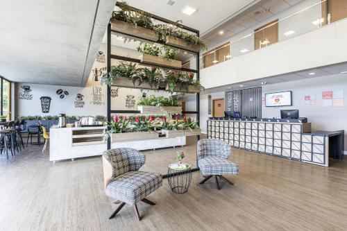 um átrio com cadeiras e um balcão com plantas em Graal Inn Mairiporã em Mairiporã