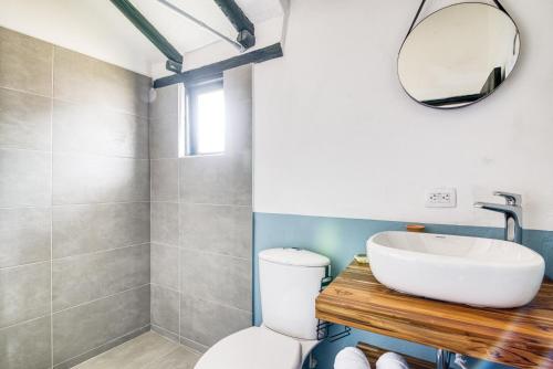 a bathroom with a sink and a toilet and a mirror at Selina Villa De Leyva in Villa de Leyva