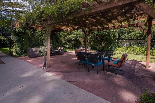 a patio with a table and chairs under a pergola at Kaleidoscope Inn & Gardens in Nipomo