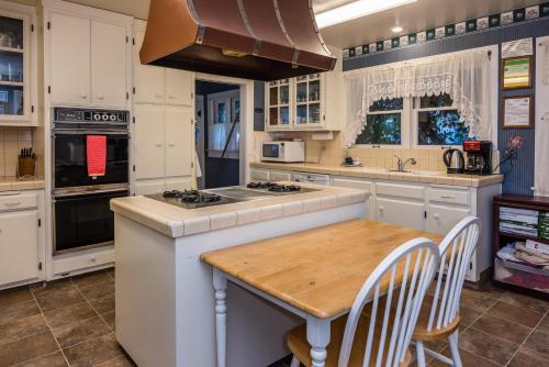 a kitchen with white cabinets and a wooden table at Kaleidoscope Inn & Gardens in Nipomo