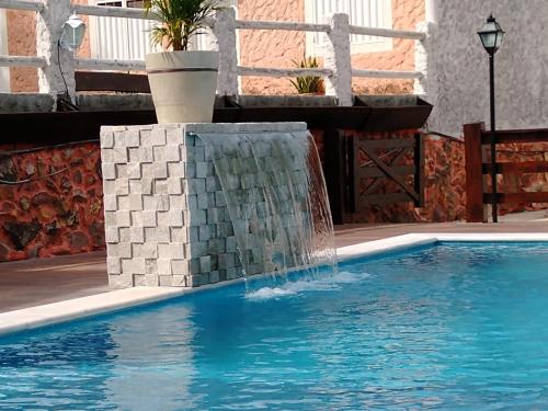 a swimming pool with a fountain in the middle at Pousada Portalcion in Goiás
