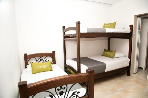 a room with two bunk beds with white and green pillows at Ayenda 1133 Casa Polty in Manizales