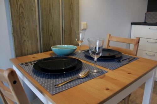 einen Tisch mit zwei Tellern und Weingläsern darauf in der Unterkunft Landzicht in Woubrugge
