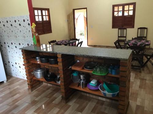 a kitchen with a counter with pots and pans at Chalé Raio De Sol in Vale do Capao