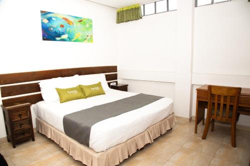 a bedroom with a bed and a table and a desk at Ayenda 1133 Casa Polty in Manizales