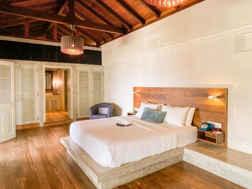 a bedroom with a large bed with a wooden headboard at The Bartizan Galle Fort in Galle