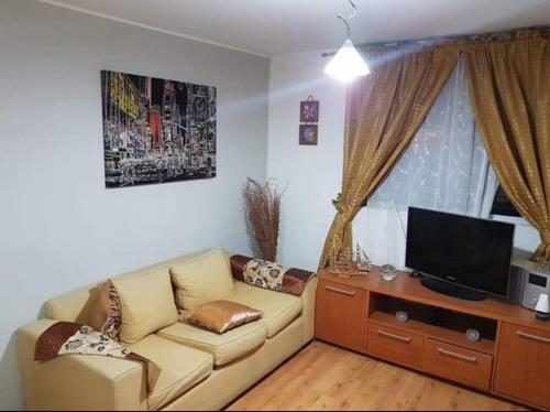 a living room with a couch and a flat screen tv at zpartment in Copiapó