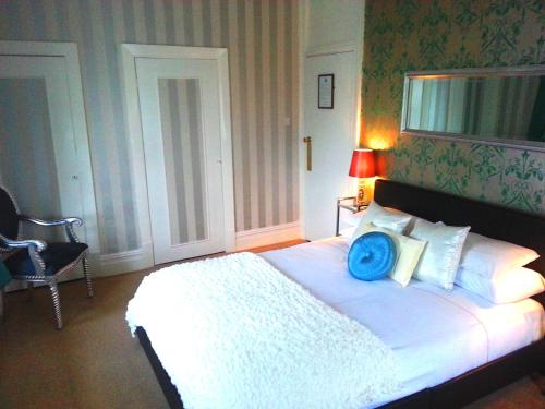 a bedroom with a bed with a blue pillow on it at The Hotel Commodore in Llandrindod Wells