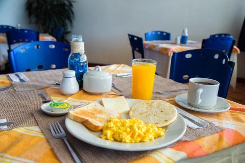 a breakfast plate with eggs toast and bread and orange juice at Ayenda 1133 Casa Polty in Manizales