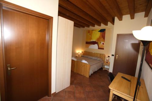 NonantolaにあるAgriturismo Casa Carpanelliのベッドとドア付きの小さな部屋