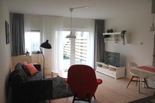 sala de estar con sofá, mesa y TV en Veldhuis, en Woubrugge